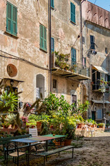 Fototapeta na wymiar Plaza mit Tischen und Bänken in der mittelalterlichen Altstadt von Cervo in Ligurien Italien