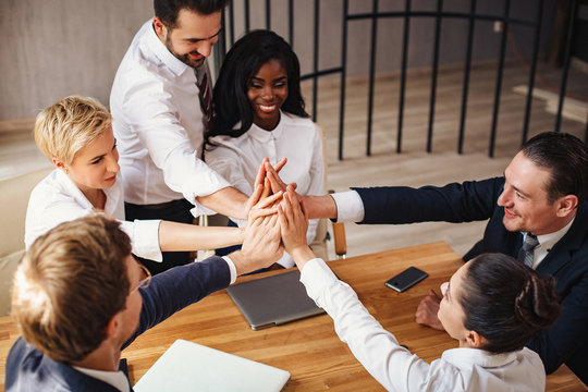 Business people join hands celebrating success