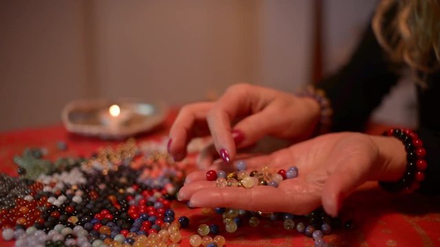 Women's hands works with Corals to make a Coral Bracelets on a Table