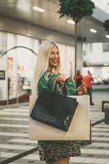  Happy young woman with shopping bags enjoying in shopping