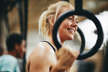 Fit woman preparing to workout with rings at the gym