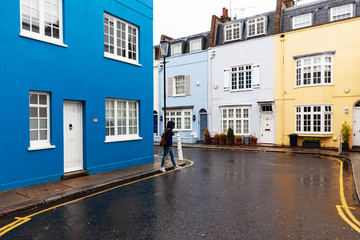 walking people on the street with colorful houses in the UK