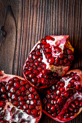 sliced pomegranate on wooden background top view