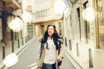 Fototapeta premium Middle-aged woman smiling and laughing happily walking through the city.
