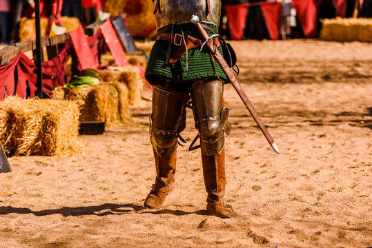 Detail the armor and shield of an actor disguised as a medieval knight in a spring festival for children.