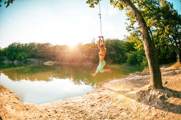 A woman is riding a swing.