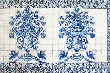 Blue traditional Portuguese ceramic tiles azulejos. Facade, wall decoration of old Coimbra university building, Portugal. Decorative background with ornaments, vase of flowers and parrot birds.
