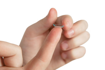 The girl holds a contact lens on the finger.