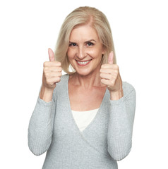 Middle aged blonde woman showing thumbs up