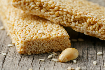 Sesame seed casinos on old vintage background with burlap cloth. Country style. Delicious sweets from seeds of sunflower, sesame and peanuts, covered with shiny glaze