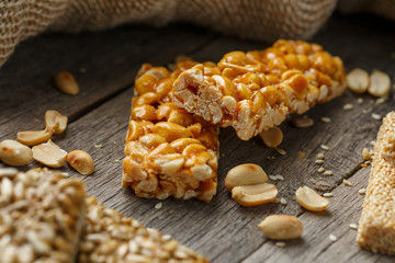 Casinak made from peanuts, on old vintage background, with burlap cloth. Country style. Delicious sweets from seeds of sunflower, sesame and peanuts, covered with shiny glaze