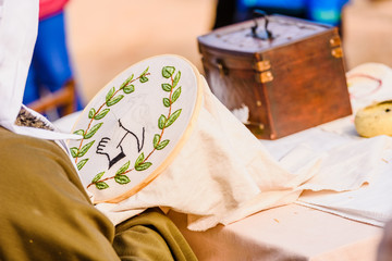 Young woman seamstress sewing a simple drawing, disguised as medieval in a traditional craft...