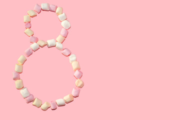 Obraz premium number eight made by small colorful marshmallow on pink background