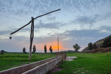Fototapeta na wymiar Traditional water well (well sweep or shadoof) in Serbia with a beautifull sunset