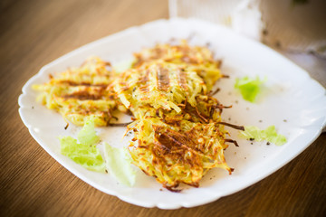 grilled potato pancakes in a plate, on a wooden table