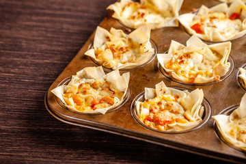 French cuisine concept. Mini cake Kish from pumpkin and goat cheese with filo dough. Cupcake baking dish. European appetizer to white wine. Top view, copy space