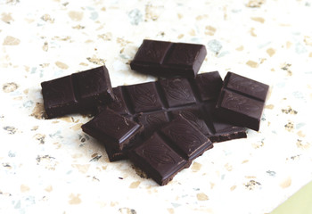 Tiles and slices of dark chocolate on the marble countertop.