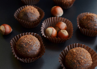 chocolate petit fours with hazelnut over black background
