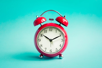 Close up red alarm clock on blue pastel background