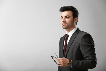 Portrait of handsome young businessman on light background