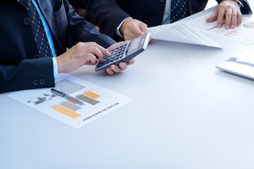 Two businessmen are deeply reviewing a financial reports for a return on investment or investment...