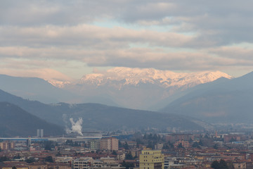 Brescia cityscape with snow covered mountains on background, Lombardy, Italy.