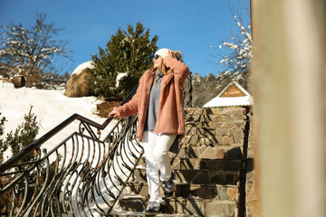 Beautiful woman on stairs at snowy resort