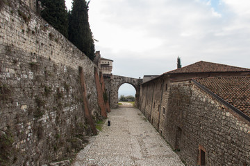 Part of a tower and a gate connecting to the wall of the Brescia Castle, Lombardy, Italy.