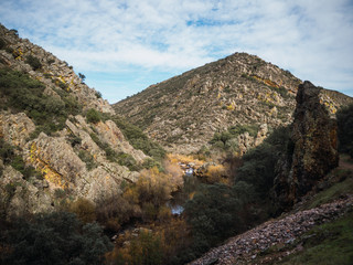 landscape of a river running through a valley on a sunny day