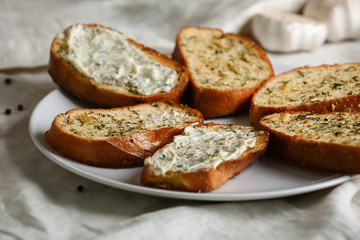 Plate with tasty cut garlic bread on table, closeup