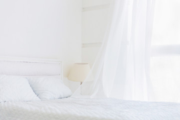 Fototapeta na wymiar Abstract white room with white bed, waving curtain on window. White room minimal interior