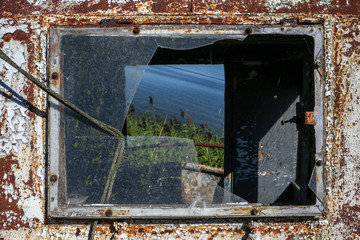 Rushes and water view in a frame of a broken ship window. In Nida, Lithuania