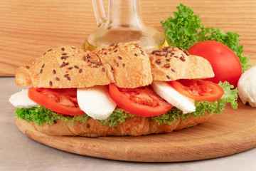 Croissant sandwich with lettuce mozzarella and tomato. Healthy snack