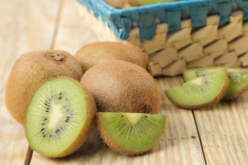 Delicious ripe many kiwi fruit and kiwi in a cut on a natural wooden table. close-up