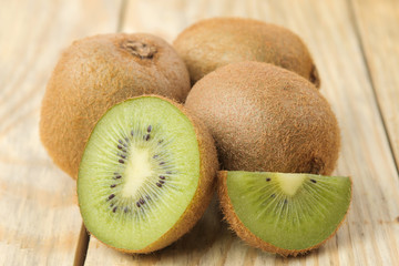 Delicious ripe many kiwi fruit and kiwi in a cut on a natural wooden table. close-up