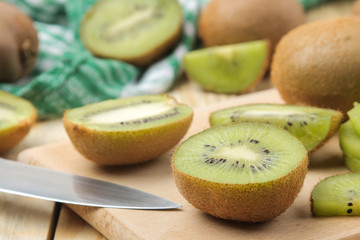 Delicious ripe lots of kiwi fruit and kiwi cutaway cut on a natural wooden table. close-up