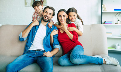 Young happy family relax together at home smiling and hugging