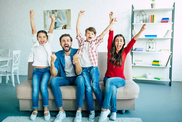 Fototapeta premium Excited big family team watch football match together on the couch at home