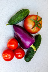 Pepper of unusual color surrounded by tomato and cucumber