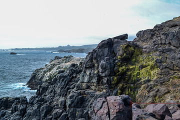 Sea cliffs in blue waters of the Pacific ocean