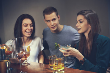 Photo of joyful friends in the bar or at pub communicating with each other