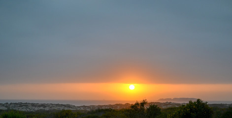 Fototapeta na wymiar Yellow sun and a cloud at sunset