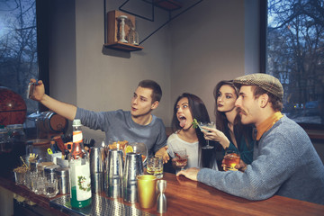 Photo of joyful friends in the bar or at pub communicating with each other