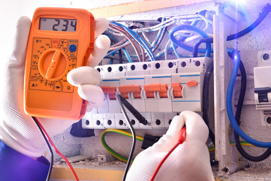 Electrical Installer With Protective Elements Making Electrical Measurements Close Up