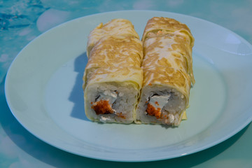 Rolls with cheese and caviar under a pancake with soy sauce