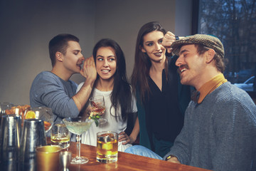 Photo of joyful friends in the bar or at pub communicating with each other