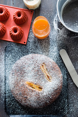 Banana cake made with almond and gluten free, shot from a top viewpoint over a rusty wooden balck background