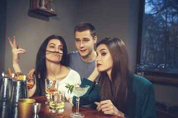 Photo of joyful friends in the bar or at pub communicating with each other