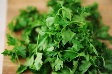 Bunch of fresh juicy parsley on a wooden cutting board closeup. Natural vitamins, background