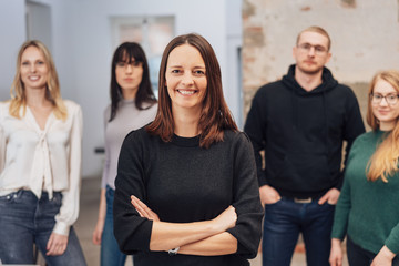 Obraz premium Smiling woman team leader with arms crossed